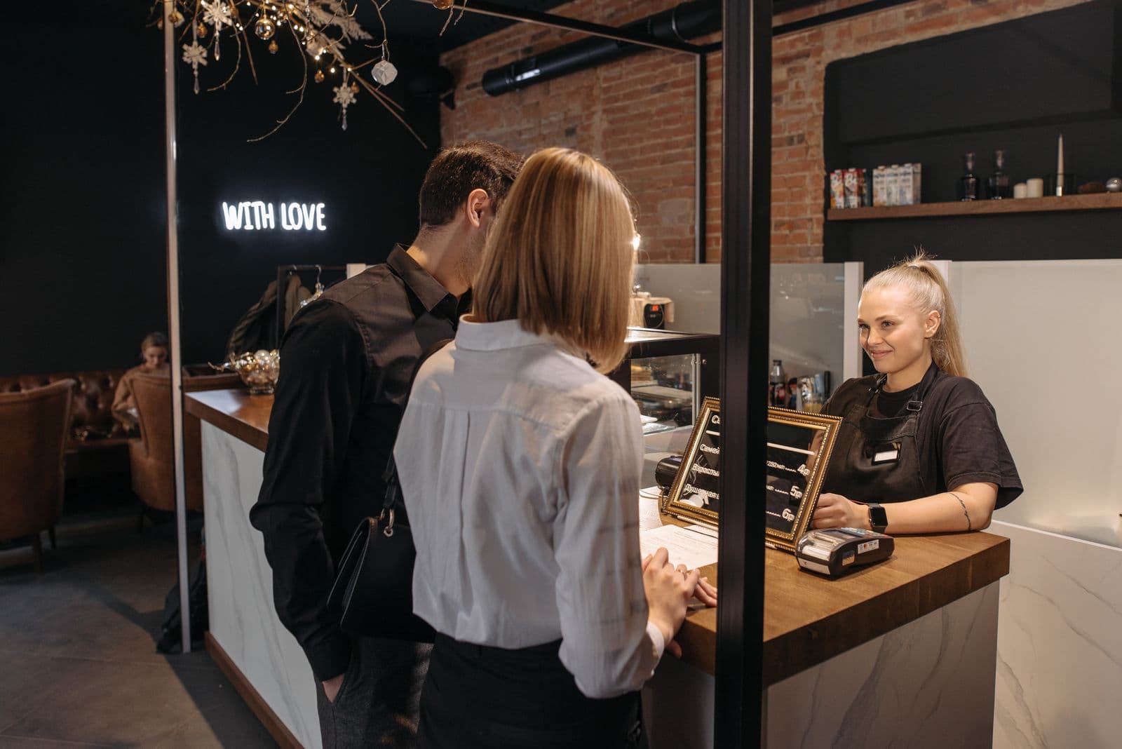 Barista serving customers at the counter of a small café