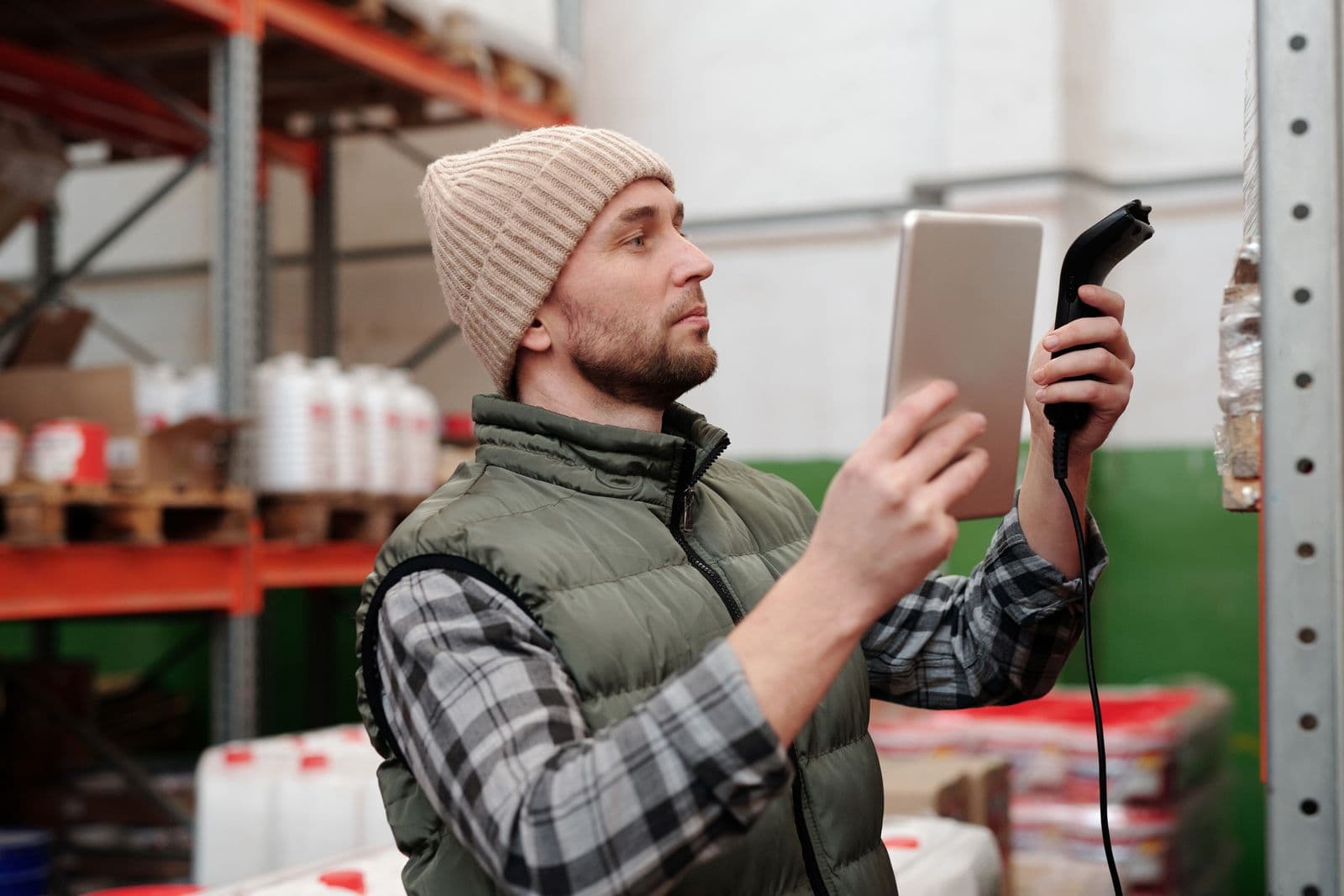 Warehouse worker scanning stock with a barcode reader and tablet
