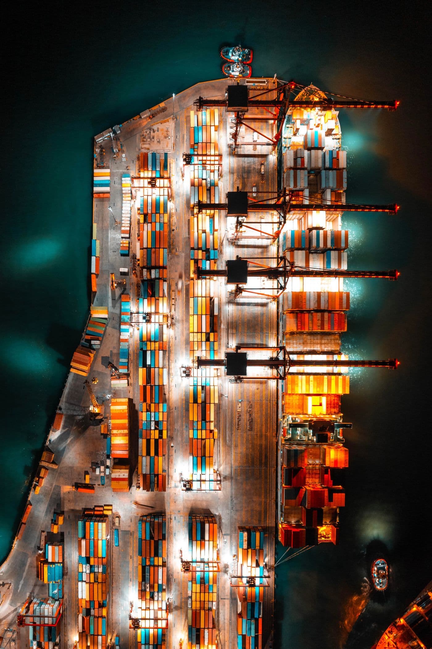 Aerial view of a container ship being loaded at a shipping port at night